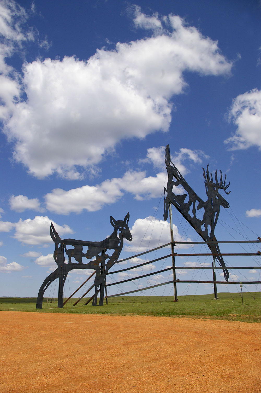 Large black metal sculpture featuring a male and female deer jumping a fence along the Enchanted Highway near Regent, North Dakota