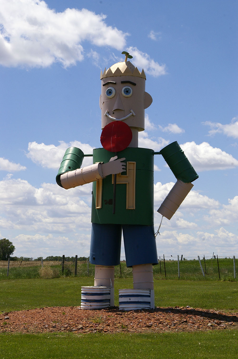 Large metal sculpture of a boy with a propellor hat licking a lollipop along the Enchanted Highway near Regent, North Dakota