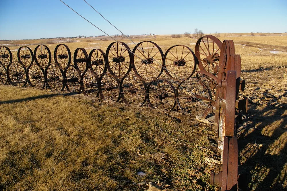 Wagon wheel fence around L.J. Maasdam's Wheel Art located in a field near Grinnell, Iowa