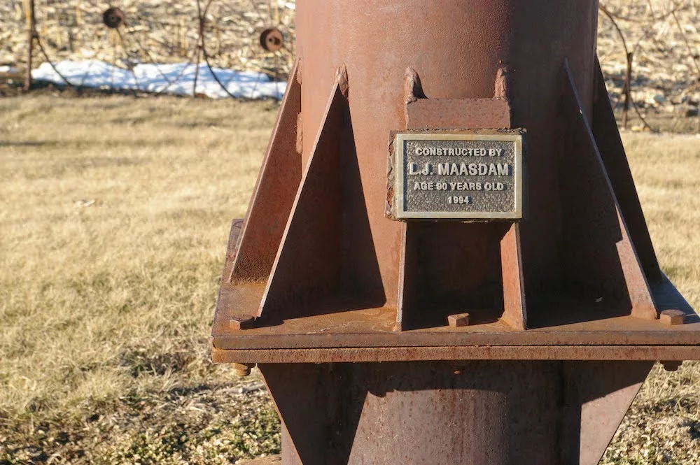 Plaque attached to L.J. Maasdam's Wheel Art located in a field near Grinnell, Iowa