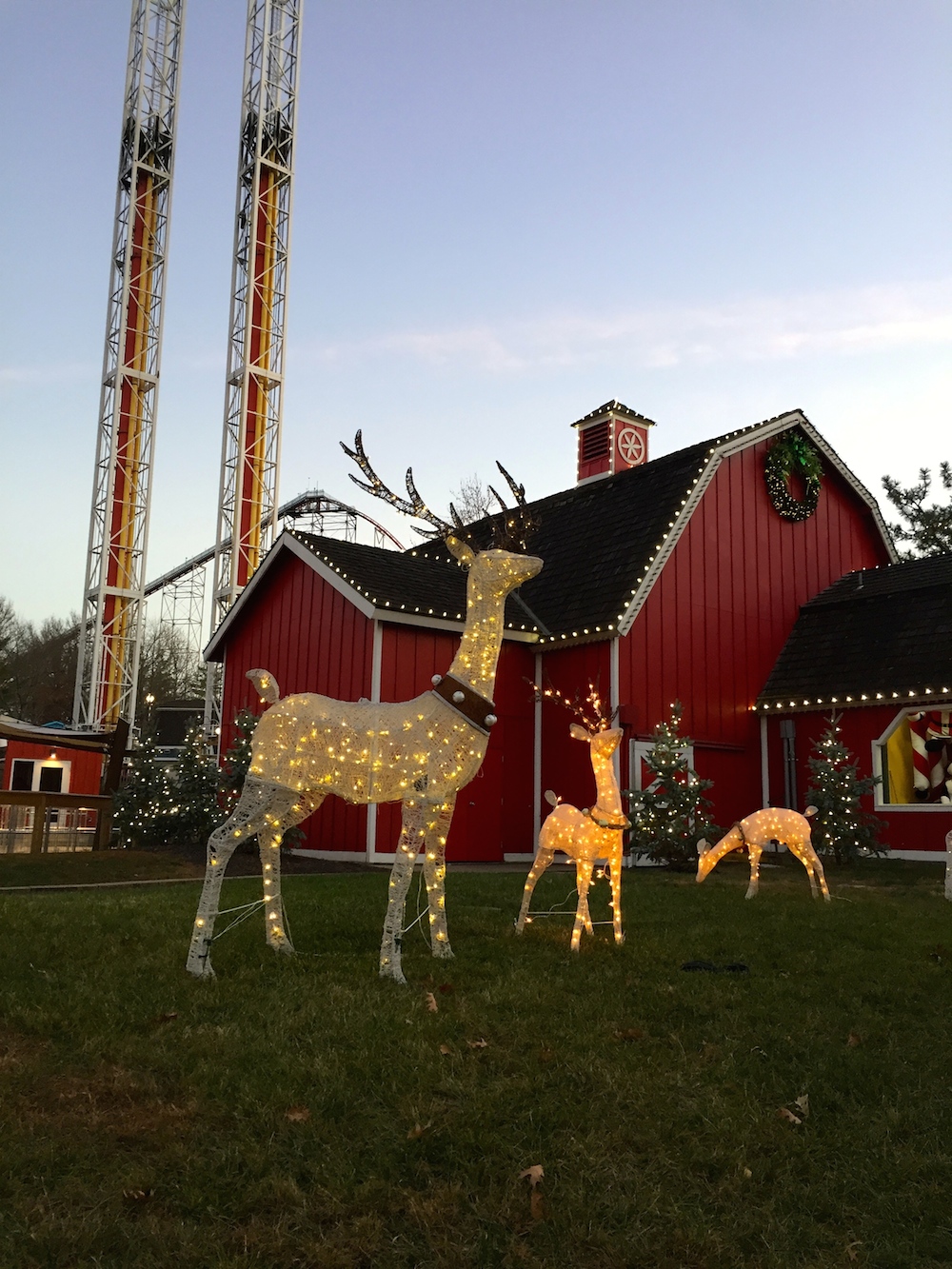 White light reindeer in front of a red barn at Worlds of Fun's WinterFest in Kansas City, Missouri
