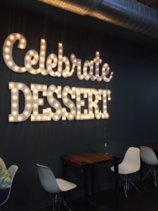 Sign made of lights reading Celebrate Dessert in the dining room of Milkfloat in Wichita, Kansas