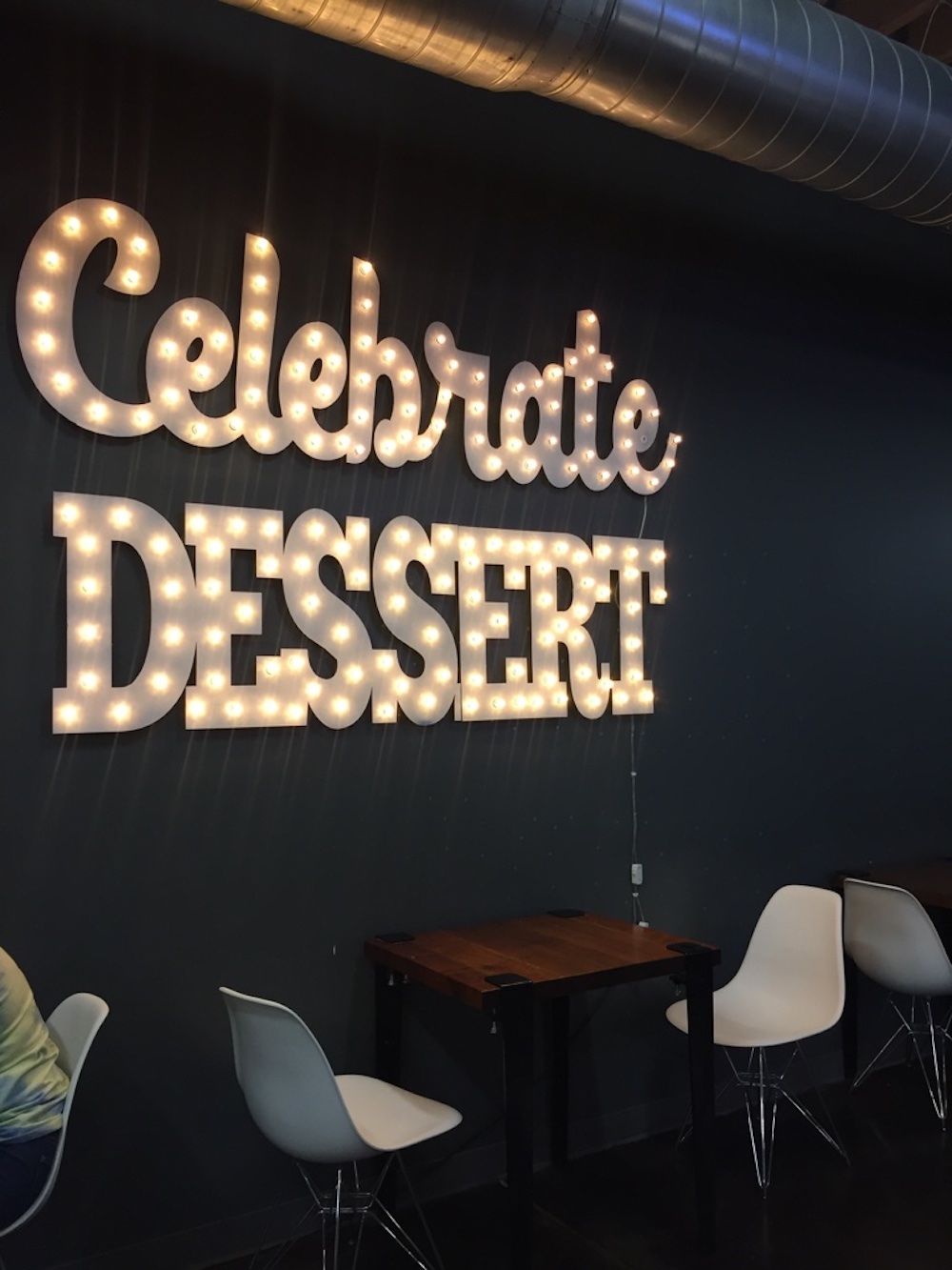 Sign made of lights reading Celebrate Dessert in the dining room of Milkfloat in Wichita, Kansas