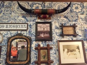 Longhorns and various artifacts mounted on a wall with blue and white floral wallpaper at the Brookville Hotel in Abilene, Kansas