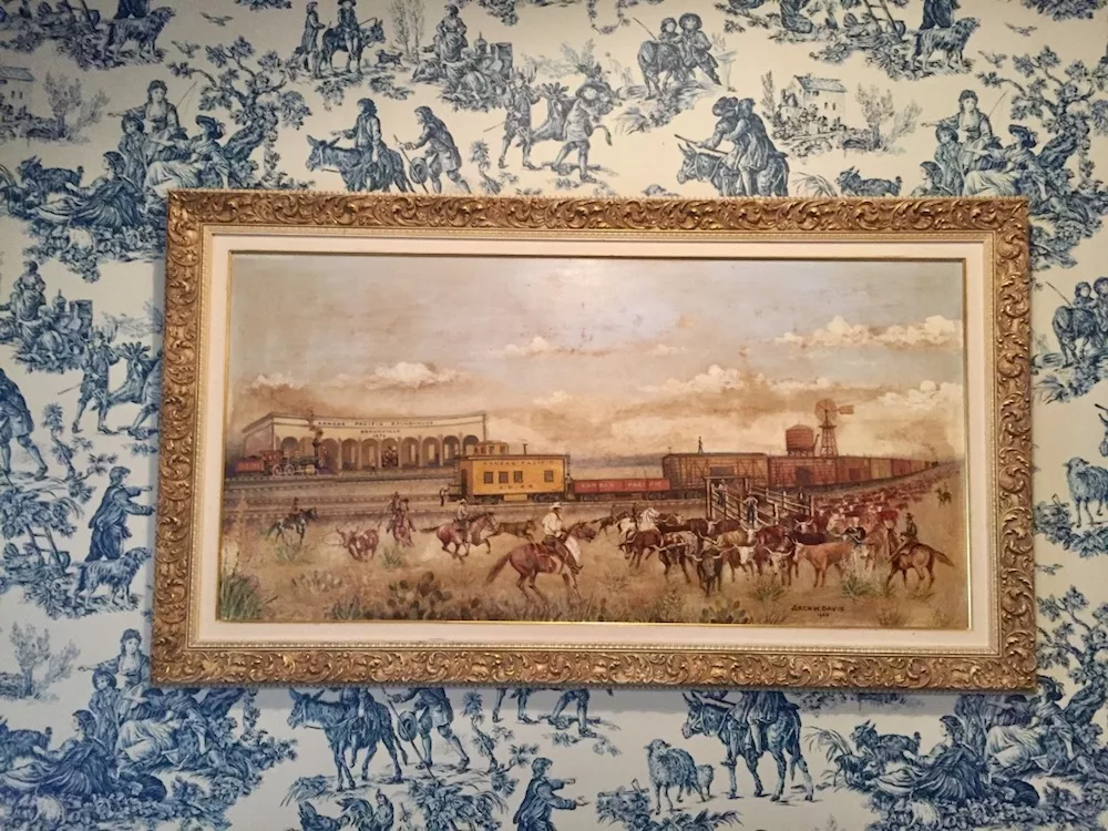 Painting of Kansas cowboys on the Chisholm Trail against blue and white wallpaper at the Brookville Hotel in Abilene, Kansas