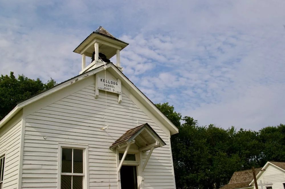 White schoolhouse with bell tower on the grounds of the Dickinson County Heritage Center in Abilene, Kansas