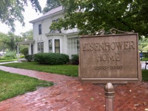 Bronze sign reading Eisenhower Home in front of a white farmhouse at the Eisenhower Presidential Library & Museum in Abilene, Kansas
