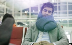 Man wearing Huzi Infinity Pillow in an airport