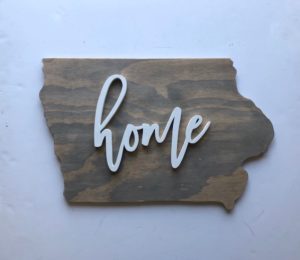 Wooden sign in the shape of Iowa reading "home" by Rosella Margaret