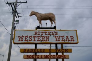 Sign for Rittel's Western Wear with plastic horse on top in Abilene, Kansas