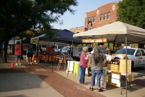 Customers shopping at a booth at the Old Town Farmers' Market in Wichita, Kansas