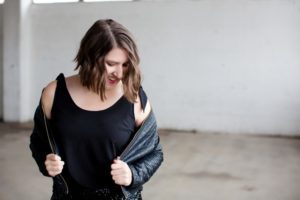 Photo of brunette woman dressed in all black looking down