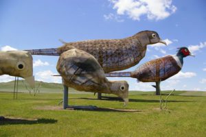 Large metal pheasant sculpture with red and green head along the Enchanted Highway near Regent, North Dakota