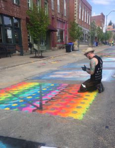 Artist creating rainbow chalk art during Mount Vernon's 2019 Chalk the Walk