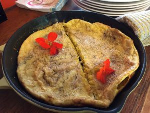 Dutch baby in a cast iron skillet with orange flowers at Thistle's Summit in Mount Vernon, Iowa