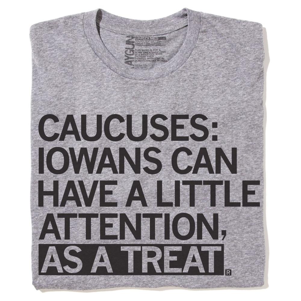 Gray T-shirt made by RAYGUN that says "Caucuses: Iowans can have a little attention as a treat."