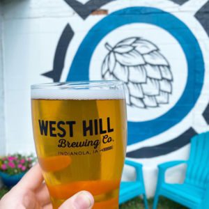 Pint of beer in front of mural at West Hill Brewing Company in Indianola, Iowa