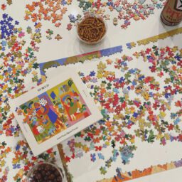 Whiled Ladies Who Lounge puzzle in-progress surrounded by snacks
