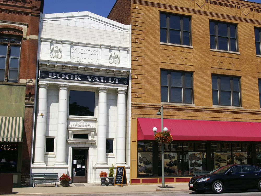 White marble exterior of a historic bank now home to the Book Vault in Oskaloosa, Iowa