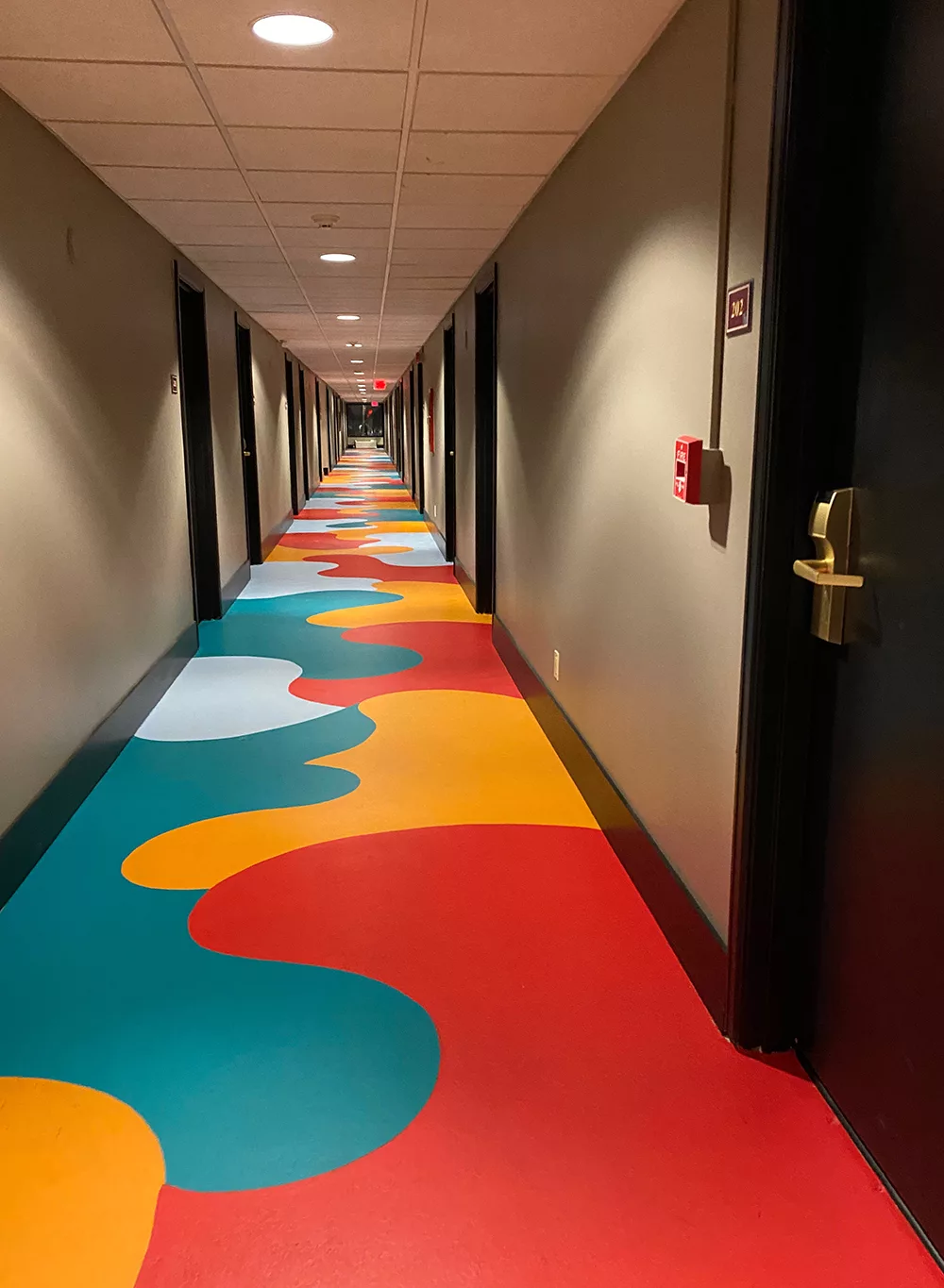 Hallway with red, orange and teal blobs painted on the floor