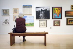 Person sitting on a bench looking at art
