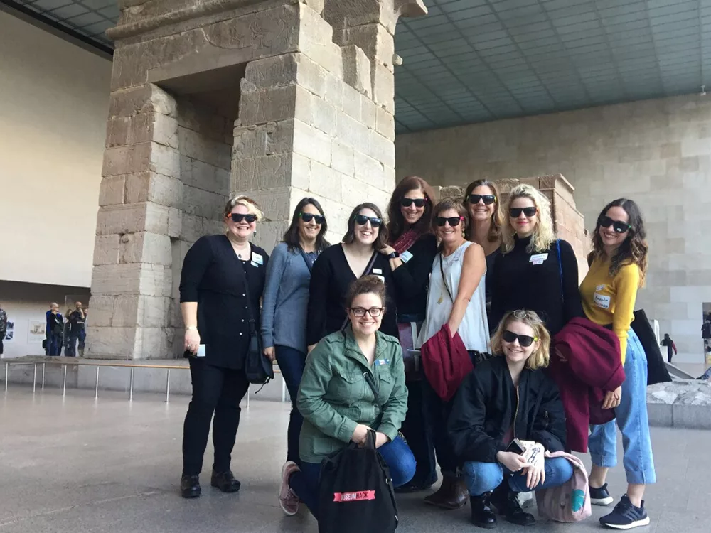 Group of people on a Museum Hack tour in front of an Egyptian tomb at the Metropolitan Museum of Art in New York City