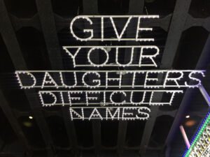 Installation made from lights that says "Give your daughters difficult names" outside the Whitney Museum of American Art in New York City