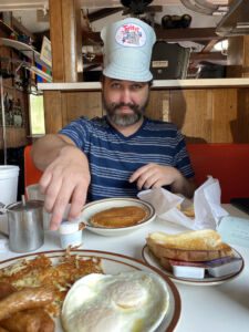 Man wearing paper hat with eggs, hash browns and pancakes at Fritz's Railroad Restaurant in Kansas City, Kansas