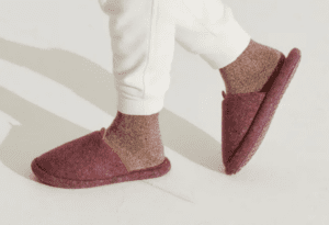 Two feet wearing Allbirds Wool Dwellers slippers