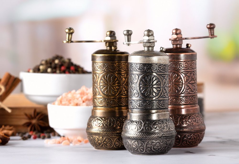 Image of three metal pepper and spice hand mills from Crystalia