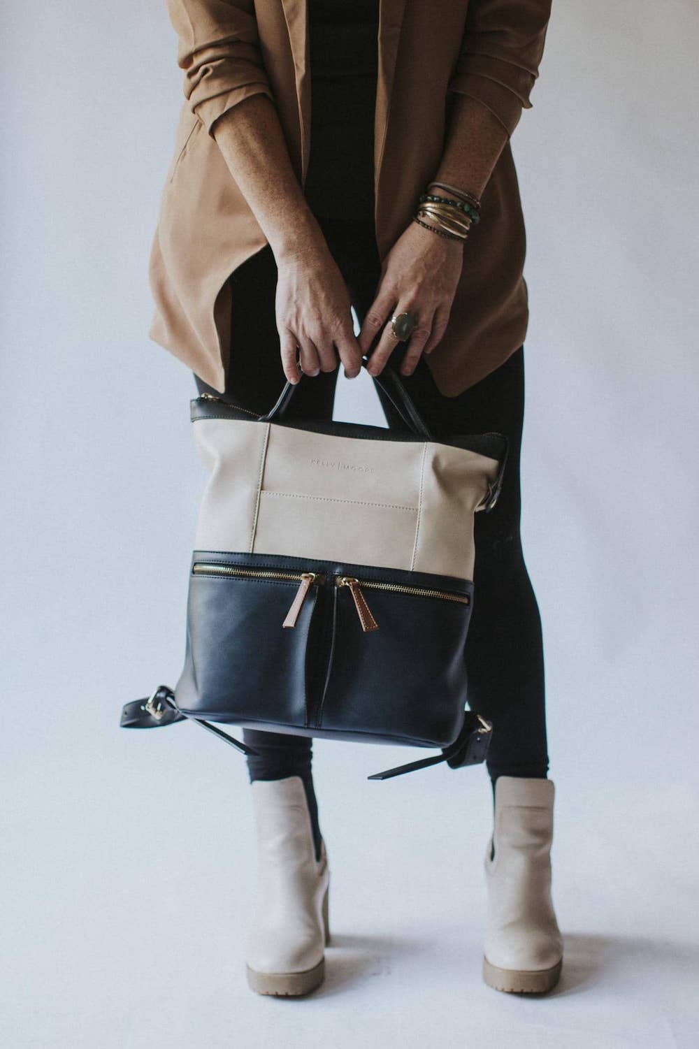 Woman holding a white and charcoal bag from Kelly Moore Bags