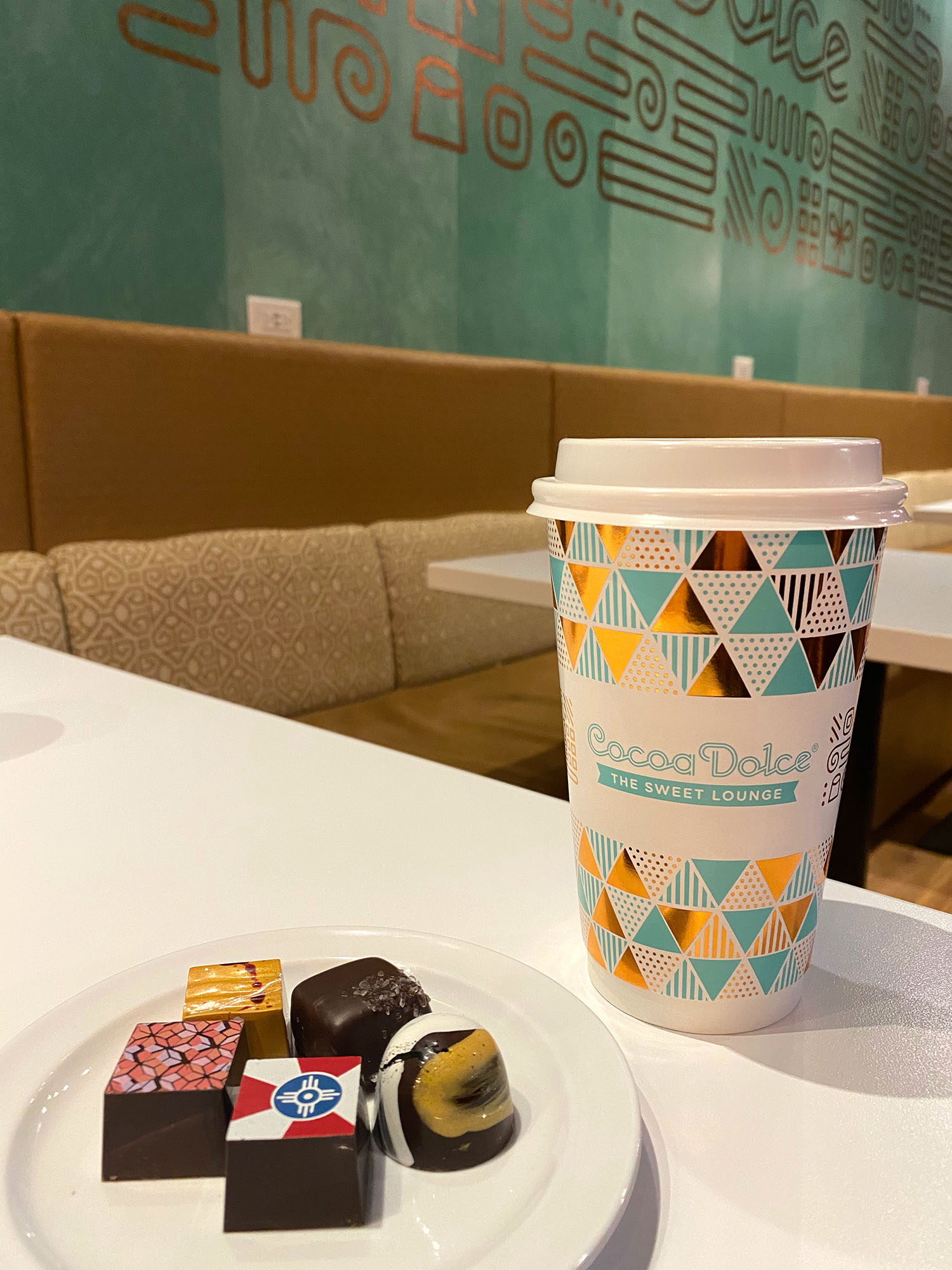 Coffee cup and plate of handmade chocolates at Cocoa Dolce in Wichita, Kansas