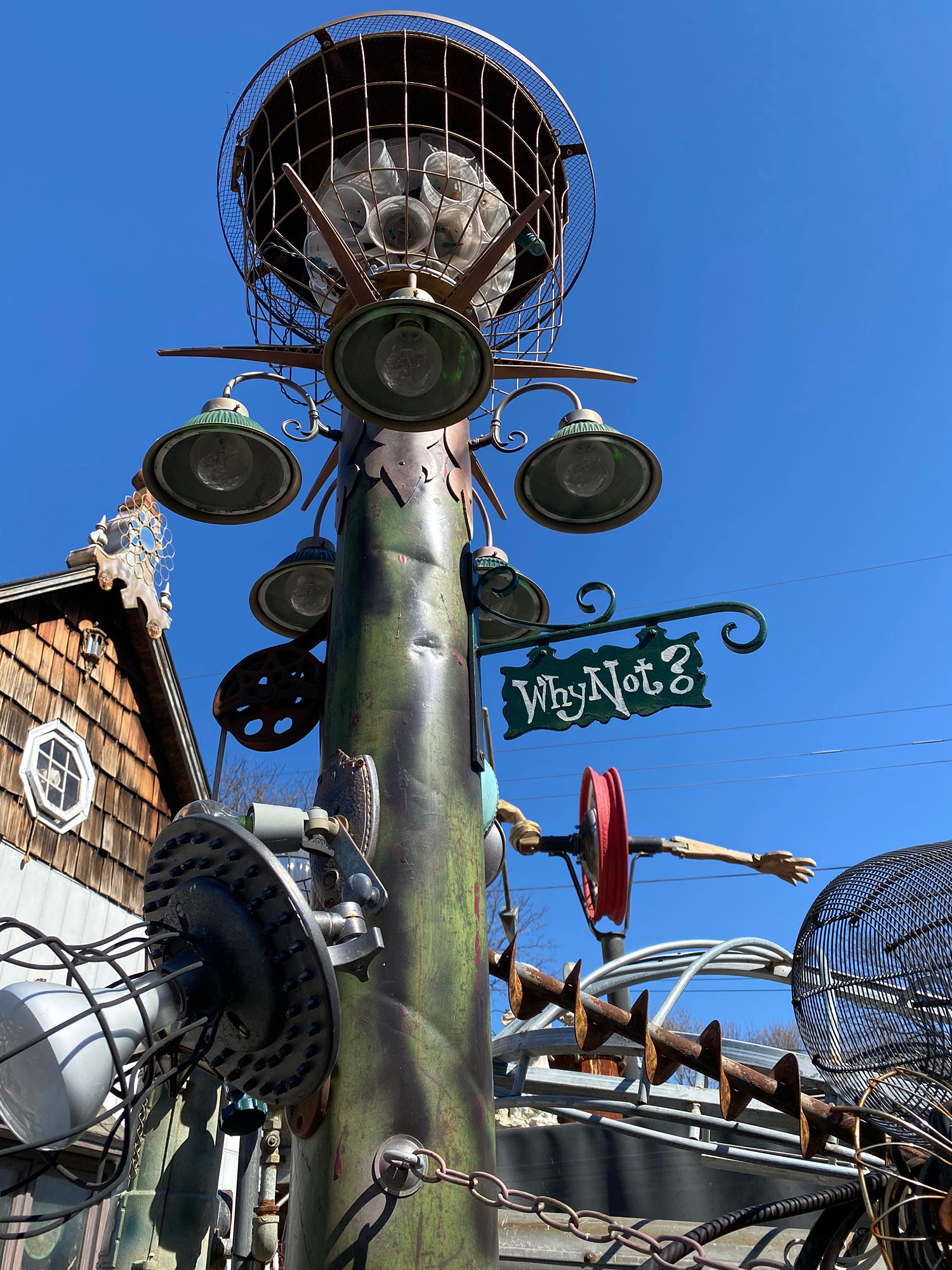 Modified light post sculpture with a sign that says "Why Not?" at Gary Pendergrass' steampunk art installation in Wichita, Kansas