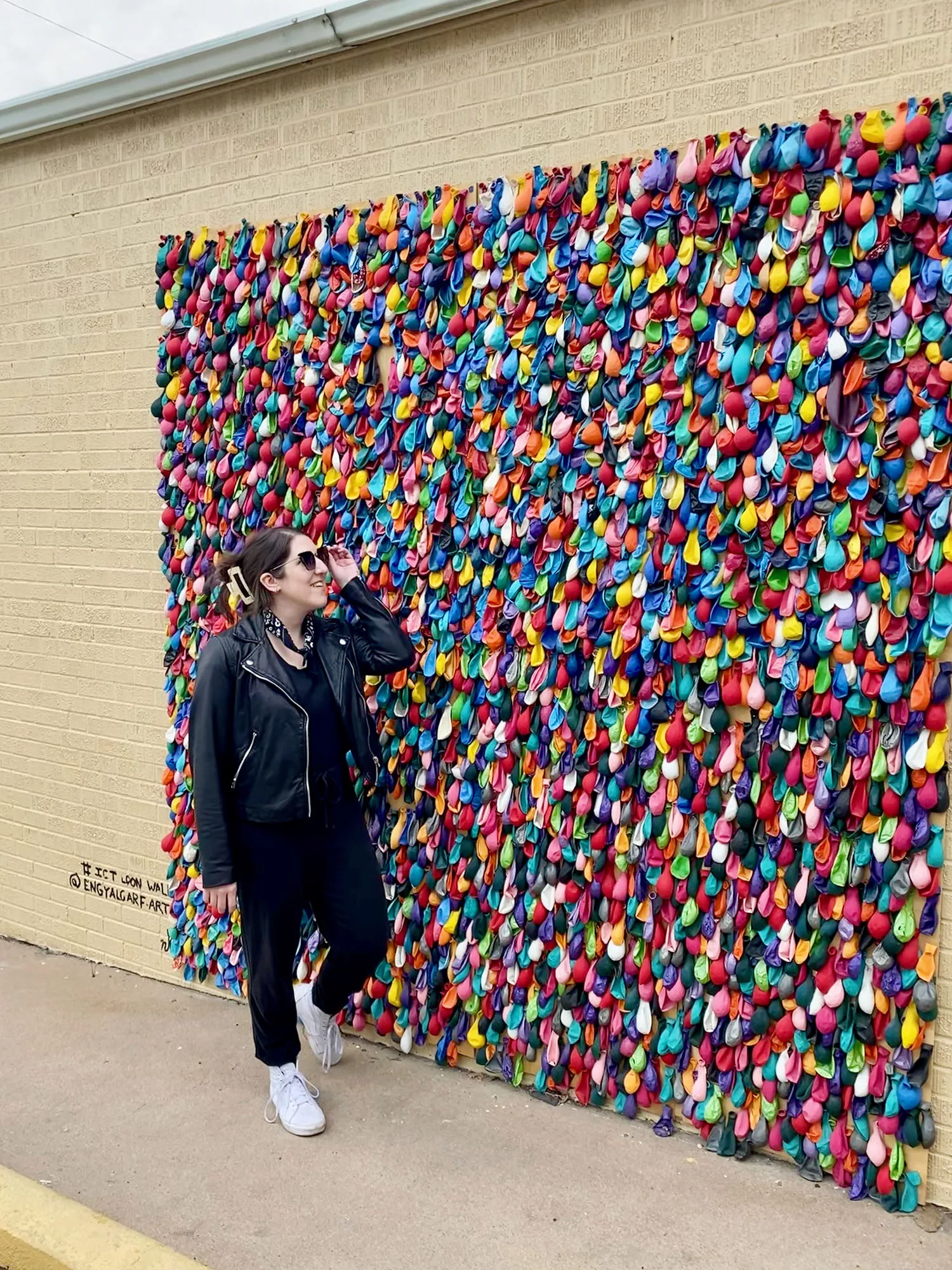 Woman standing in front of balloon wall at Local Roasters in Wichita, Kansas