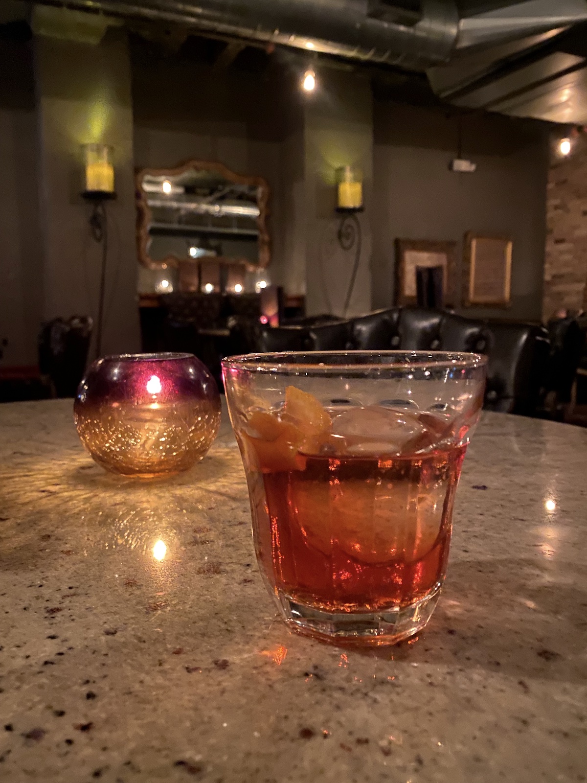 Negroni sitting on a table with a candle at Dockum in Wichita, Kansas