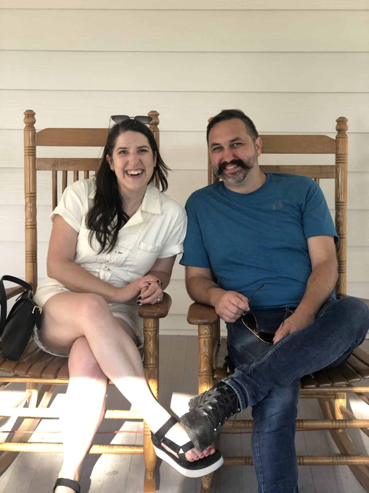 Two people sitting in rocking chairs smiling at the camera