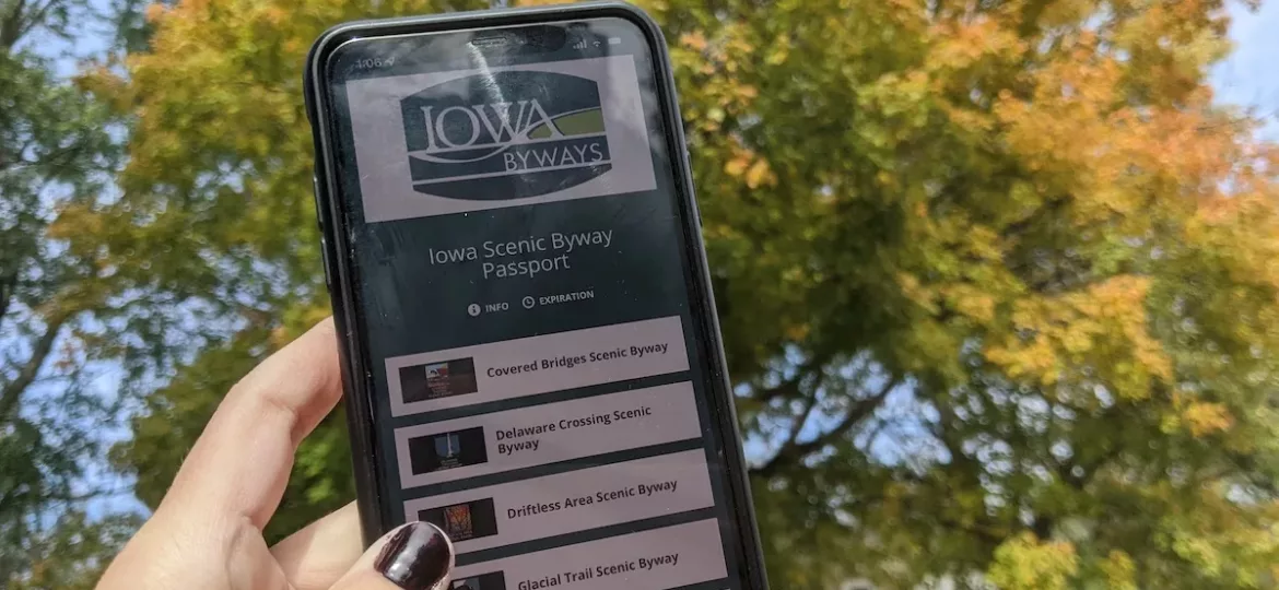 Hand holding phone with Iowa Scenic Byway Passport on screen