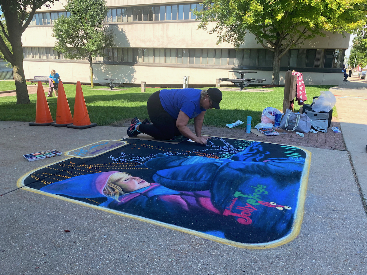 Person making chalk art piece during Art Infusion in Janesville, Wisconsin