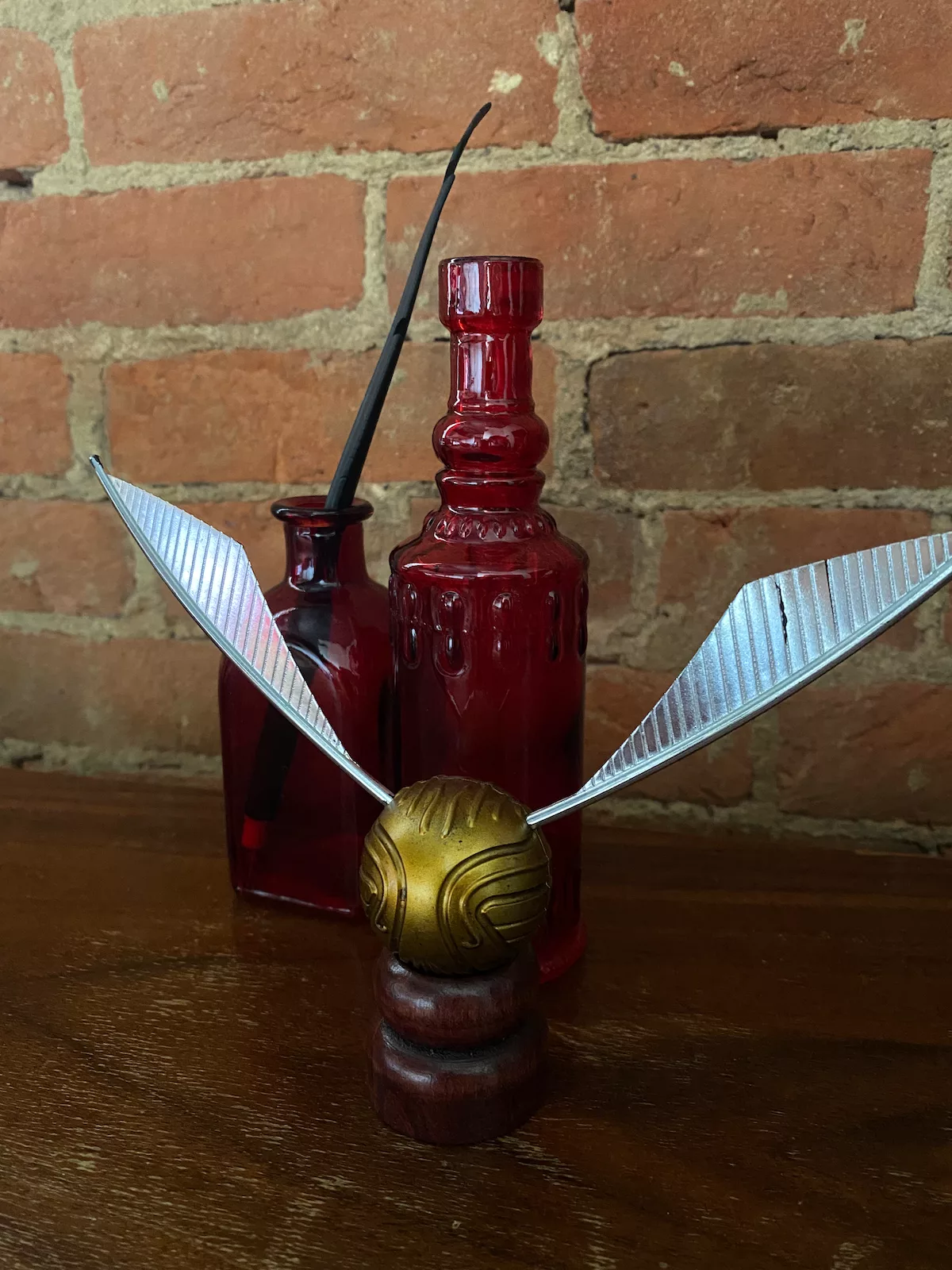 Golden snitch and quill on table in Room 303 at the Eighteen-Ninety Sleepover in Casey, Illinois