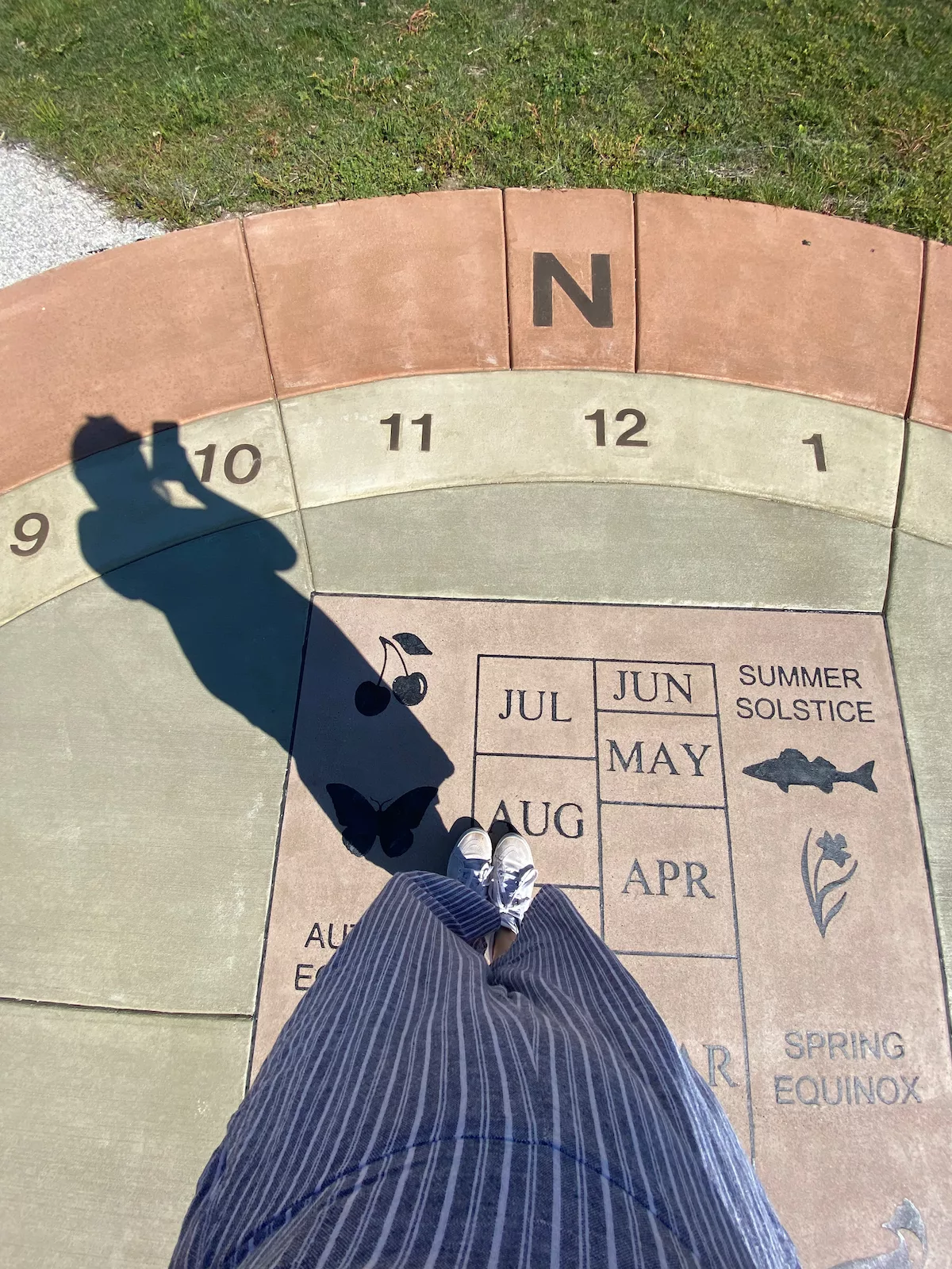 Person standing on Joan and John Evans Legacy Sundial in Lions Park in Janesville, Wisconsin
