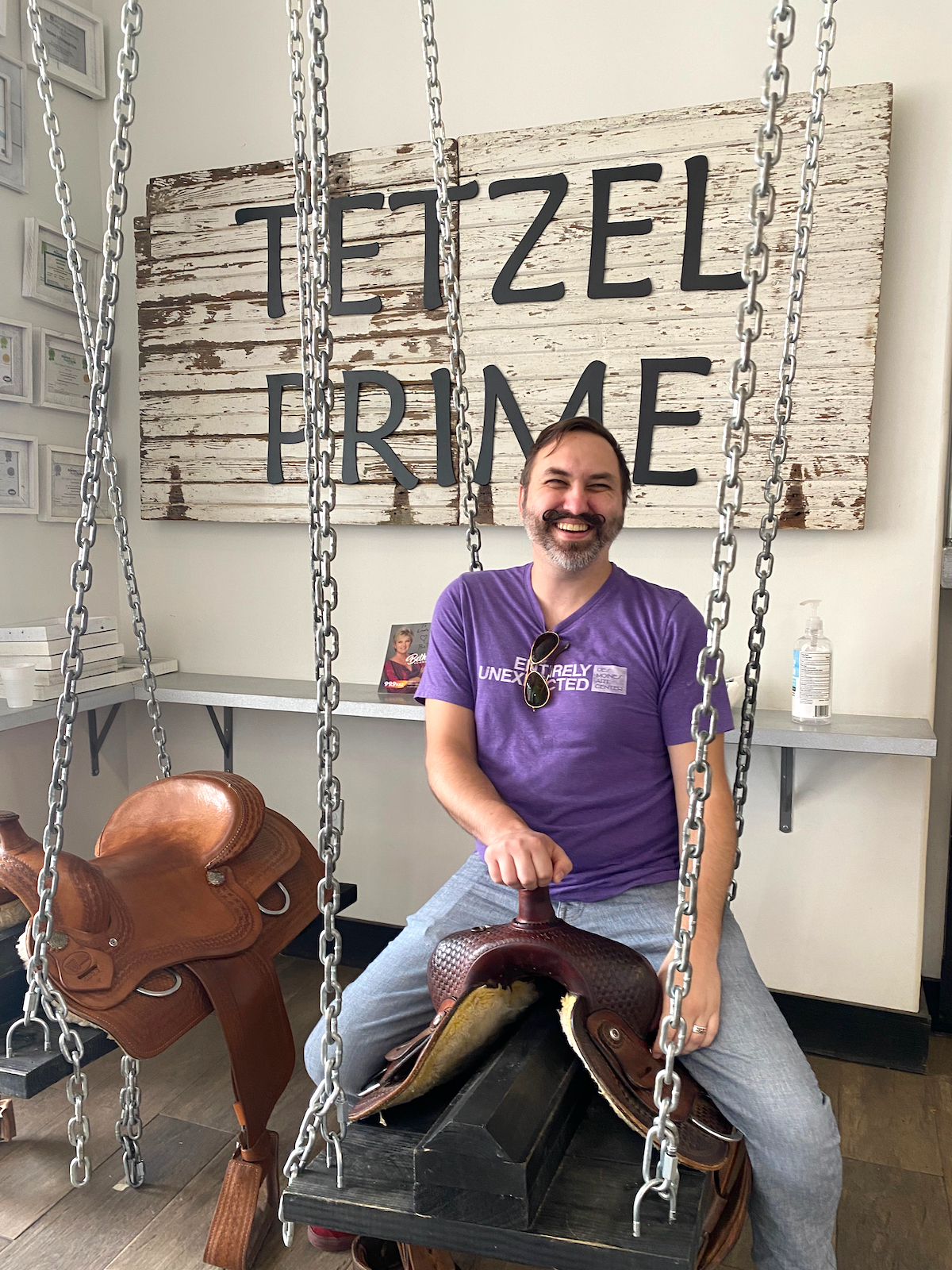 Man sitting on saddle swing at Tetzel Prime in Casey, Illinois