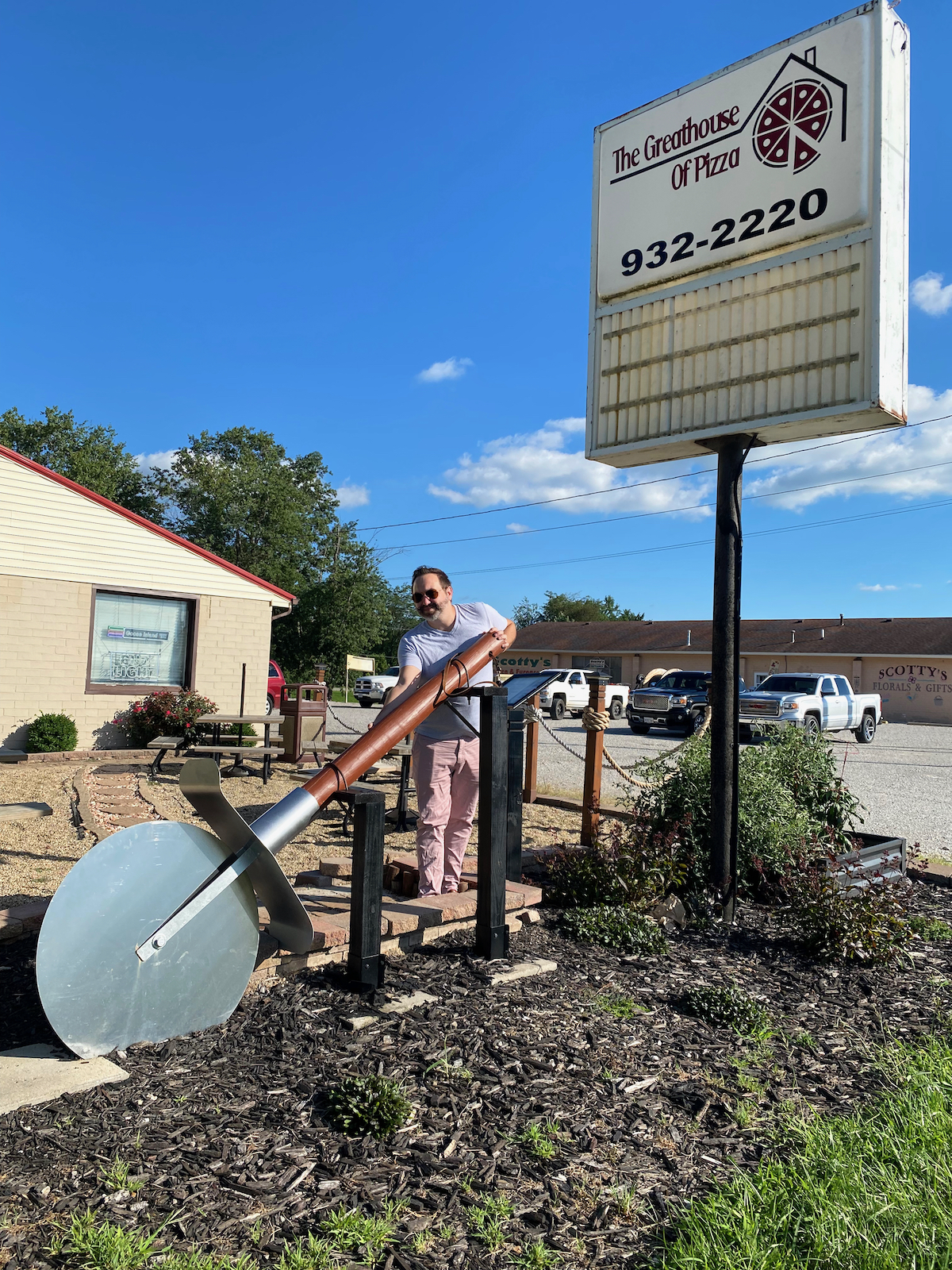 Man holding Big Pizza Slicer outside of the Greathouse of Pizza in Casey, Illinois
