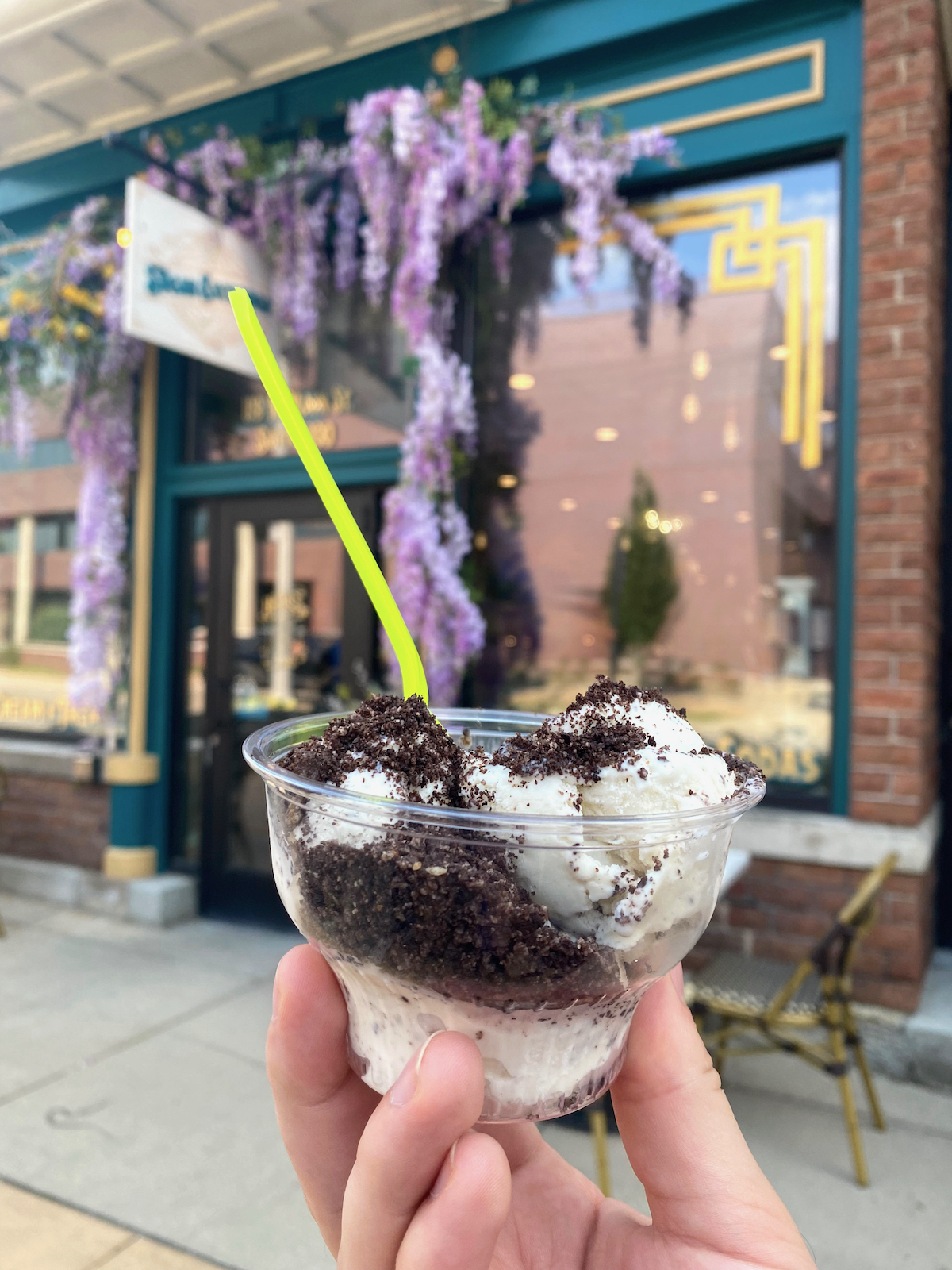 Hand holding cup of ice cream in front of The Sugar Exchange in Janesville, Wisconsin