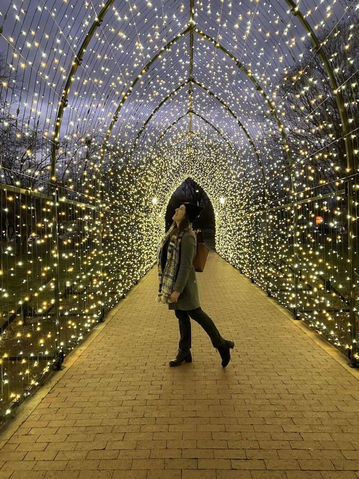 Woman standing under archway of lights in Central Park in Pella, Iowa
