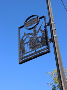 Metal cut out lamp pole art of women doing the cancan in Dodge City, Kansas