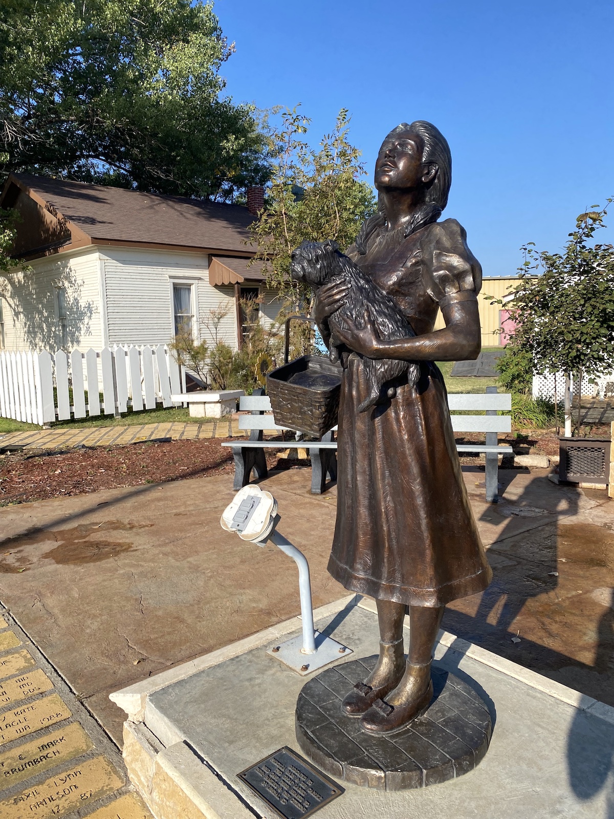 Bronze statue of Dorothy Gale holding Toto outside of Dorothy's House & Land of Oz in Liberal, Kansas