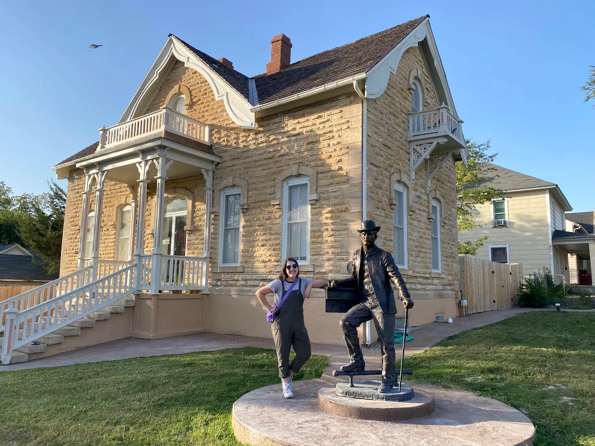 Woman posing bronze statue outside of the Mueller-Schmidt House - Home of Stone in Dodge City, Kansas