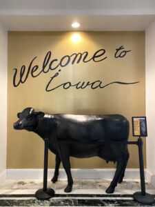 Cow statue and mural that says "Welcome to Iowa" at The Current hotel in Davenport, Iowa