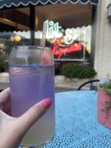 Hand holding a Gin Eyre cocktail outside of The Literary in Champaign, Illinois
