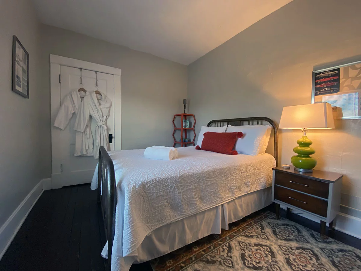 Bedroom with bed and side table lamp at the Old Riverton Post B&B in Riverton, Kansas